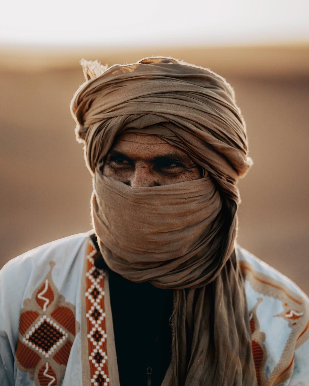 Daday, desert driver and route specialist, wearing a desert turban and embroidered robe.